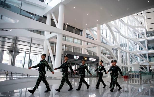 La policía paramilitar china desfila en el interior del Aeropuerto Internacional de Daxing, recién inaugurado en Beijing, el 28 de septiembre de 2019. (Noel Celis/AFP vía Getty Images)