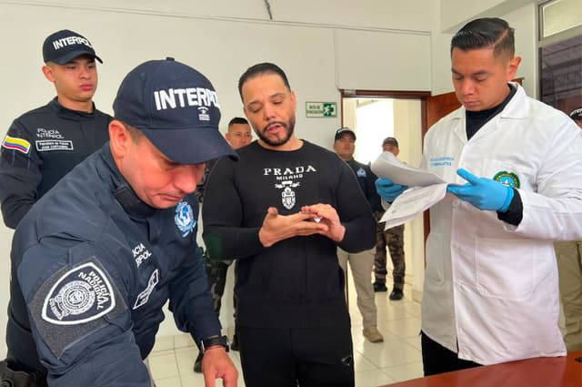 Fotografía cedida por la oficina de prensa de la Policía Nacional de Colombia que muestra a Erick Randhiel Mosquea Polanco (c), presunto cabecilla de la organización criminal conocida como Red Falcón, este sábado en Bogotá (Colombia). Colombia extraditó a Estados Unidos al dominicano Erick Randhiel Mosquea Polanco, supuesto líder de la organización criminal desarticulada con la operación Falcón en República Dominicana, informaron las autoridades. (EFE/ Interpol Dijin)