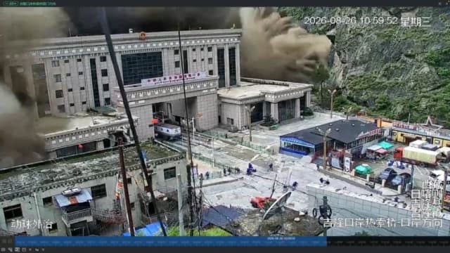 Una imagen de CCTV muestra a personas huyendo mientras un muro de lodo y agua destruye edificios en un valle en la frontera entre Nepal y China, en Gyirong, región del Tíbet, China, el 26 de agosto de 2026, en esta captura de pantalla obtenida de un video de redes sociales. (Redes Sociales/vía Reuters)