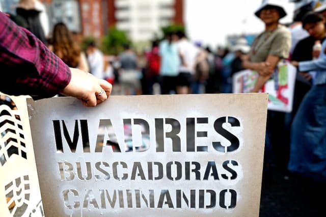 Una mujer sostiene un cartel que dice "Madres en busca de sus hijos, caminando" durante una manifestación el Día de las Madres, en Guadalajara, estado de Jalisco, México, el 10 de mayo de 2026. (ULISES RUIZ / AFP vía Getty Images)