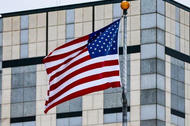 En una foto de archivo, una bandera ondea al viento en una embajada de Estados Unidos. (Gleb Garanich/Reuters, archivo).