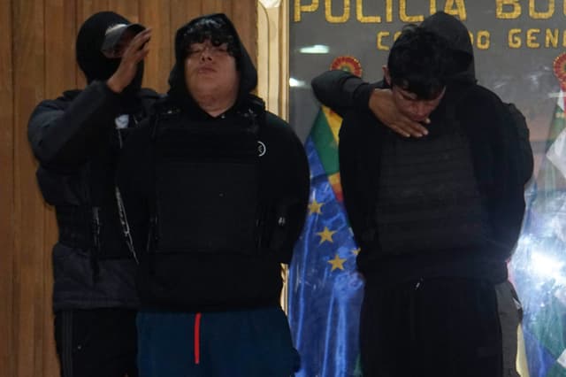 Integrantes de la Policía de Bolivia fueron captados este 1 de septiembre al presentar a Jhonsson Smit Cruz Torres, apodado Jhonsson Pulpo (d), considerado el principal líder de la banda criminal peruana Los Pulpos, quien fue capturado este martes, junto a Saúl M.G. (2-i), en La Paz, Bolivia. (EFE/STR)