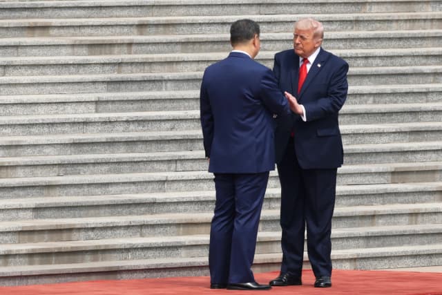 El presidente Donald Trump (derecha) es recibido por el líder chino Xi Jinping durante una ceremonia de bienvenida en Pekín el 14 de mayo de 2026. (Alex Wong/Getty Images)