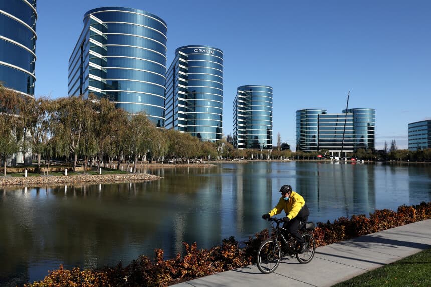 Un guardia de seguridad monta en bicicleta frente a la antigua sede de Oracle en Redwood Shores, California, el 9 de diciembre de 2021. (Justin Sullivan/Getty Images).