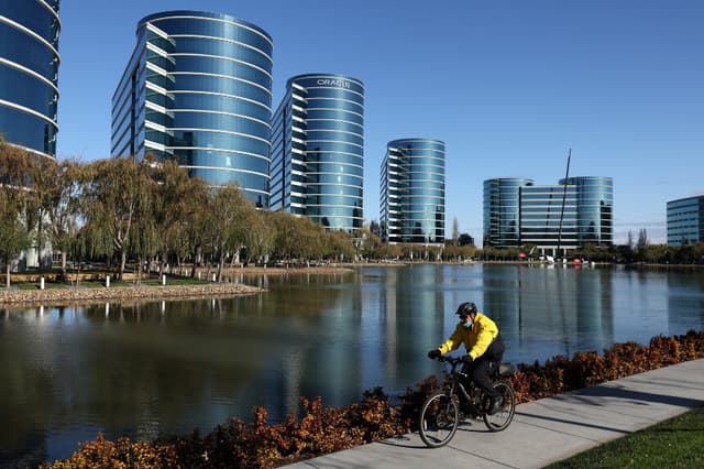 Un guardia de seguridad monta en bicicleta frente a la antigua sede de Oracle en Redwood Shores, California, el 9 de diciembre de 2021. (Justin Sullivan/Getty Images).