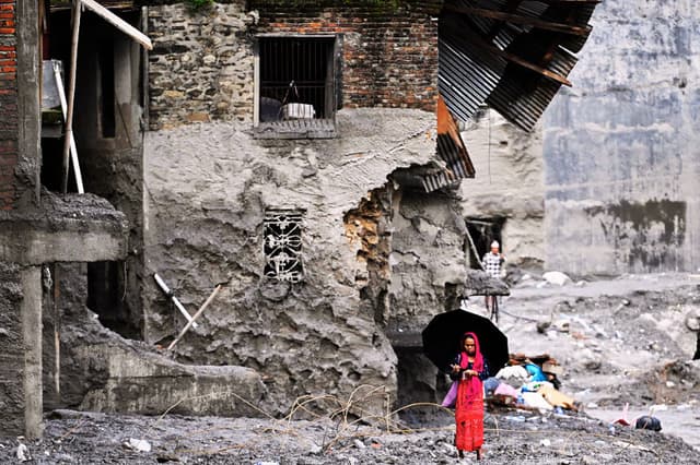 Una mujer camina entre las ruinas causadas por las inundaciones repentinas en el distrito de Nuwakot, en Nepal, el 1 de septiembre de 2026. (Arun SANKAR / AFP vía Getty Images)