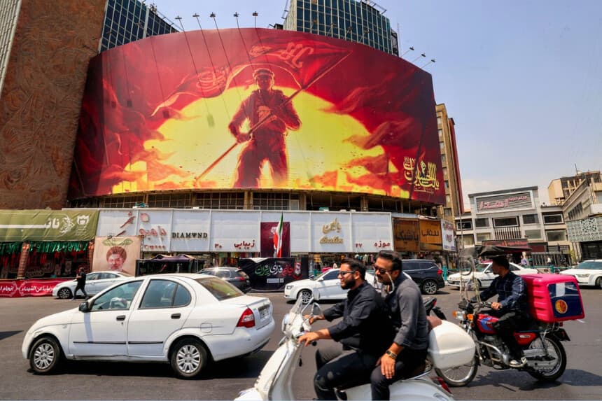 Los conductores pasan en coche frente a una valla política en la Plaza Valiasr, en el centro de Teherán, Irán, el 8 de agosto de 2026. (Atta Kenare/AFP vía Getty Images).