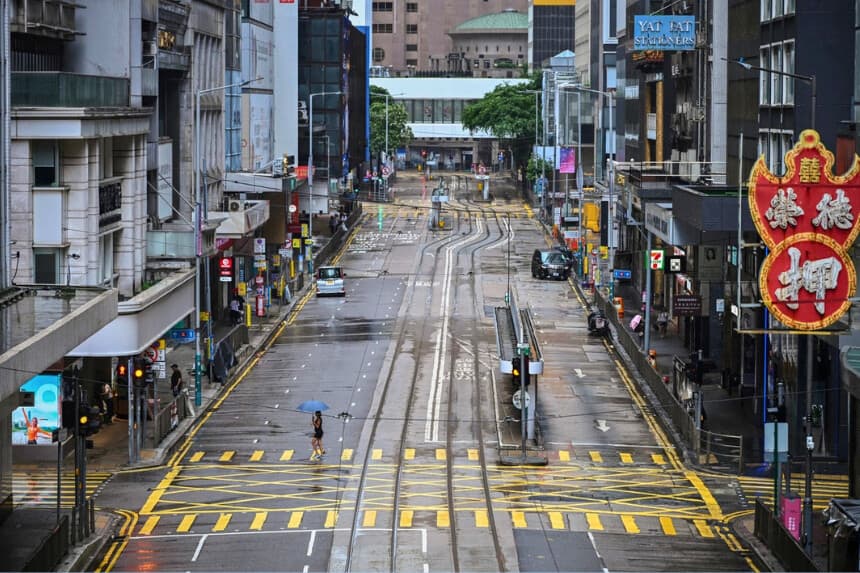 Una mujer cruza una calle vacía en el distrito Central mientras el tifón Wipha se dirige hacia Hong Kong el 20 de julio de 2025. (Peter Parks/AFP vía Getty Images).