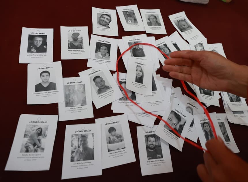 Una persona muestra imágenes de personas desaparecidas en la Ciudad de México. (Imagen de archivo. EFE/ Mario Guzmán)