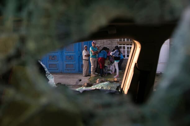 Se ve a varias personas a través de un agujero de bala en un vehículo tras un enfrentamiento entre habitantes del pueblo y agentes de la policía estatal en Arantepacua, municipio de Nahuatzen, estado de Michoacán, México, el 5 de abril de 2017. (ENRIQUE CASTRO/AFP vía Getty Images)