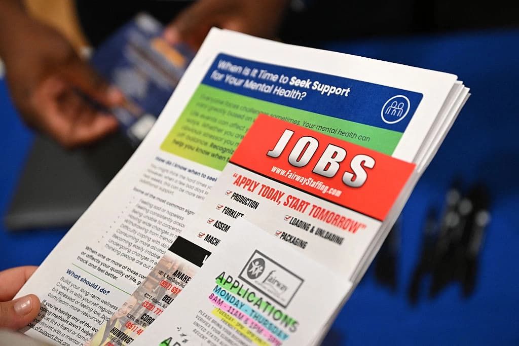 Una persona en busca de empleo sostiene un folleto de una empresa de reclutamiento en una feria de empleo y recursos en Los Ángeles, el 29 de julio de 2026. (Patrick T. Fallon / AFP vía Getty Images)