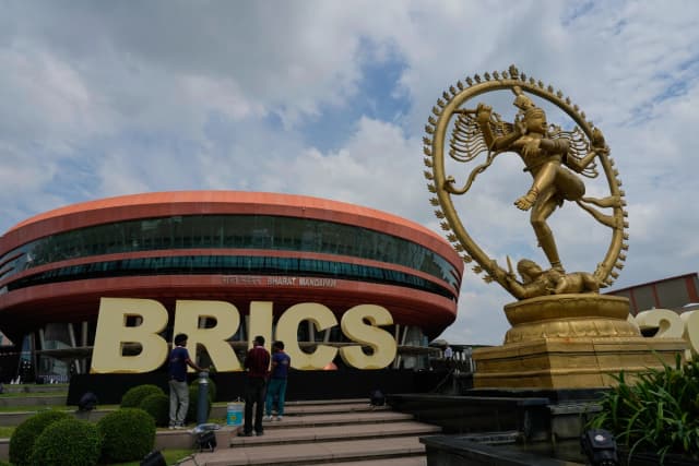 Trabajadores dan los últimos retoques a un letrero de los BRICS antes de la cumbre en Bharat Mandapam, Nueva Delhi, India, el 12 de septiembre de 2026. (Foto de Manish Swarup/AP).