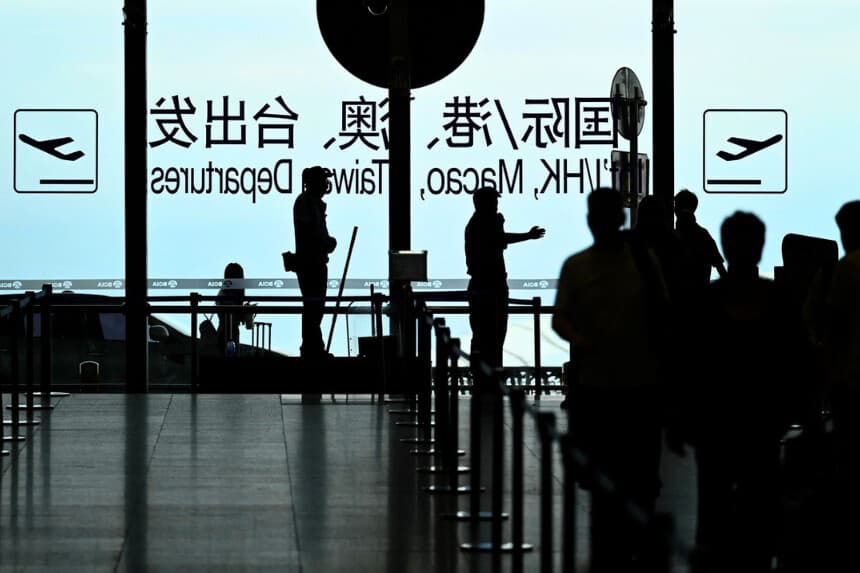 Un guardia de seguridad guía a los pasajeros en el aeropuerto internacional de Pekín el 6 de julio de 2025. (Wang Zhao/AFP vía Getty Images)