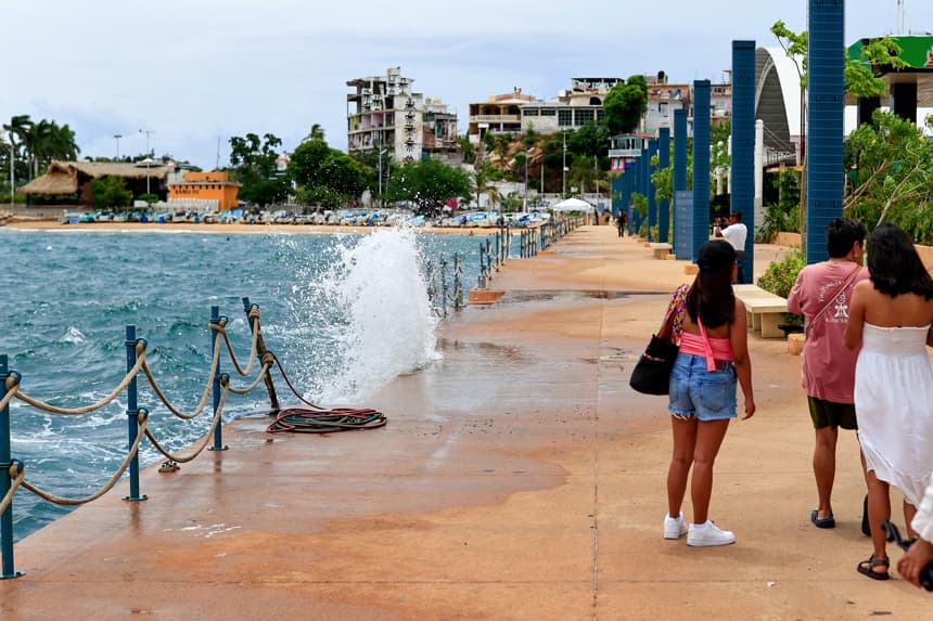 Personas caminan por el malecón con fuerte oleaje ante el paso del huracán 'Polo' este martes en Acapulco, México. (EFE/ David Guzmán)