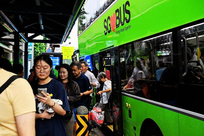 Varias personas bajan de un autobús público en Singapur el 21 de septiembre de 2026. Los pasajeros que coman en los autobuses públicos o pongan los pies en los asientos ahora se enfrentan a una multa de casi 500 SGD (392 USD) en Singapur, según informaron las autoridades el 21 de septiembre, lo que constituye un nuevo ejemplo de las normas estrictas de la "Ciudad de las Multas". (Roslan RAHMAN / AFP vía Getty Images)