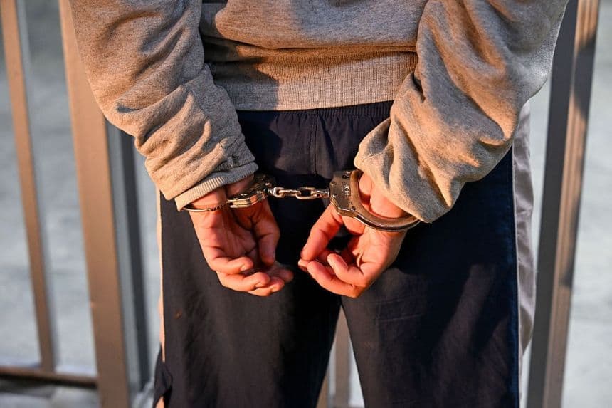 Un hombre es esposado durante un registro en el Palacio de Justicia de la Ciudad de Guatemala, el 5 de agosto de 2025. (JOHAN ORDONEZ/AFP vía Getty Images)