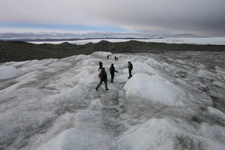 Turistas en el casquete glaciar de Groenlandia el 3 de septiembre de 2007. Aunque el 80 por ciento de Groenlandia está cubierto de hielo, bajo este se encuentran abundantes recursos naturales, como los elementos de tierras raras. (Uriel Sinai/Getty Images)