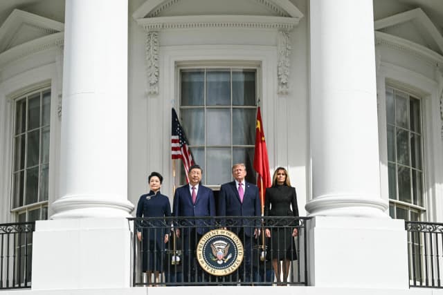 (I/D) La primera dama de China, Peng Liyuan, el presidente de China, Xi Jinping, el presidente Donald Trump y la primera dama Melania Trump se encuentran en el balcón del Salón Azul de la Casa Blanca para observar una exhibición del Pelotón de Ejercicios Silenciosos del Cuerpo de Marines de EE. UU., en Washington, el 24 de septiembre de 2026. (Saul Loeb / AFP vía Getty Images).