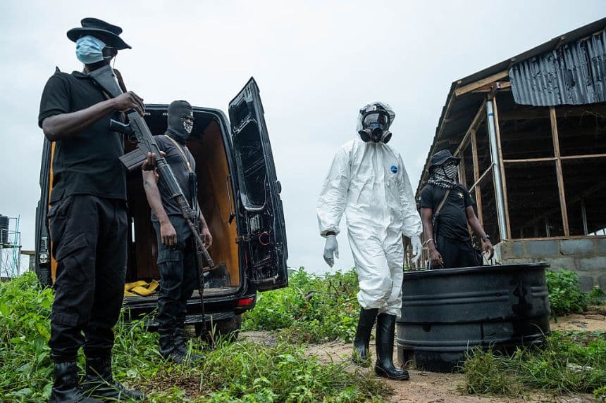 Agentes de la Agencia Nacional de Lucha contra las Drogas de Nigeria (NDLEA) se encuentran frente a un laboratorio clandestino abandonado de metanfetamina durante una operación para desmantelar el sitio en Iroto, en el área de gobierno local de Ijebu Este, estado de Ogun, el 29 de julio de 2026. (TOYIN ADEDOKUN / AFP vía Getty Images)