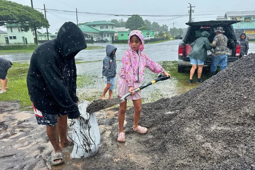 Kenzielynn Kekoa, (C), de Hilo, Hawái, ayuda a su familia a llenar sacos de arena mientras se acerca el huracán Nolo en Hilo, Hawái, el 25 de septiembre de 2026. (Foto AP/Eugene Garcia).