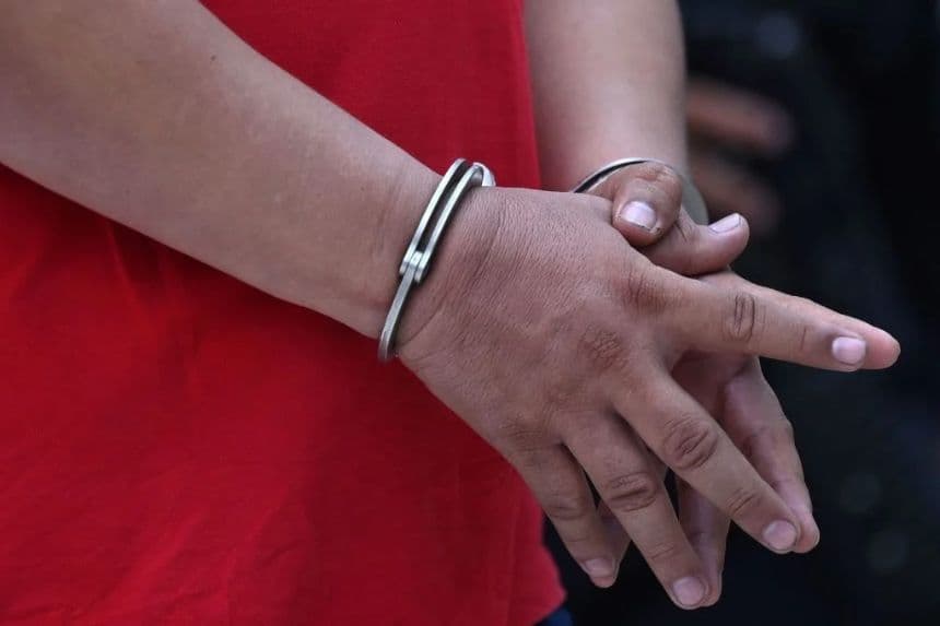 Imagen ilustrativa de un hombre esposado tras ser detenido por la Policía Nacional Civil por cargos de corrupción en San Salvador, el 26 de abril de 2021. (MARVIN RECINOS/AFP vía Getty Images)