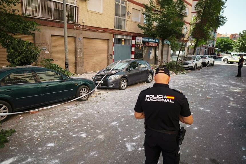 Un policía local español se encuentra junto a unos vehículos dañados tras un sismo en Granada el 18 de agosto de 2026. (JORGE GUERRERO / AFP vía Getty Images)