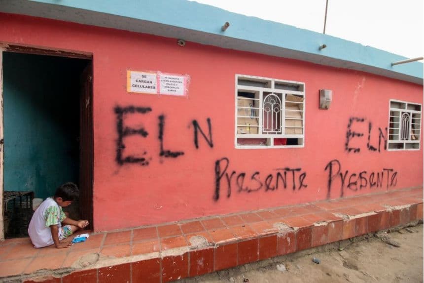 Un niño está sentado frente a una casa con un grafiti que dice "ELN (Ejército de Liberación Nacional) presente" en el barrio de La Parada, en la frontera entre Colombia y Venezuela —cerca del Puente Internacional Simón Bolívar— en Cúcuta, Colombia, el 2 de mayo de 2022. (SCHNEYDER MENDOZA/AFP vía Getty Images)