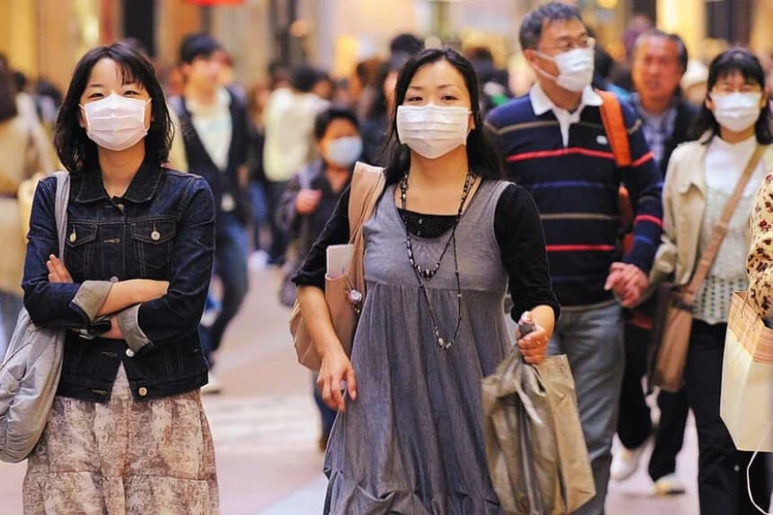 Peatones con cubrebocas caminan por una calle en el centro de Kobe, en la prefectura de Hyogo, al oeste de Japón, el 17 de mayo de 2009. (KAZUHIRO NOGI/AFP vía Getty Images)