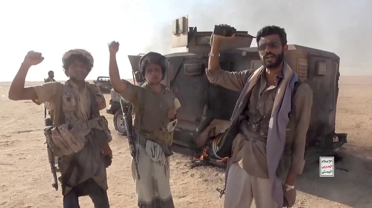 Combatientes hutíes alineados con Irán posan junto a un vehículo destruido tras lo que la fuente describió como un ataque contra fuerzas respaldadas por Arabia Saudí en la localidad indicada por la fuente como la gobernación de Al Jawf, Yemen, en esta captura de pantalla tomada de un video publicado por los Medios Militares Hutíes el 15 de septiembre de 2026. (Medios Militares Hutíes/Reuters).