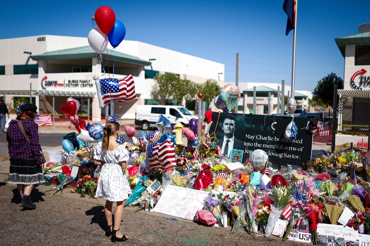 Varias personas se congregan en un monumento improvisado en memoria del comentarista conservador y fundador de Turning Point USA, Charlie Kirk, frente a la sede de Turning Point USA en Phoenix, Arizona, el 14 de septiembre de 2025. (Charly Triballeau/AFP vía Getty Images).