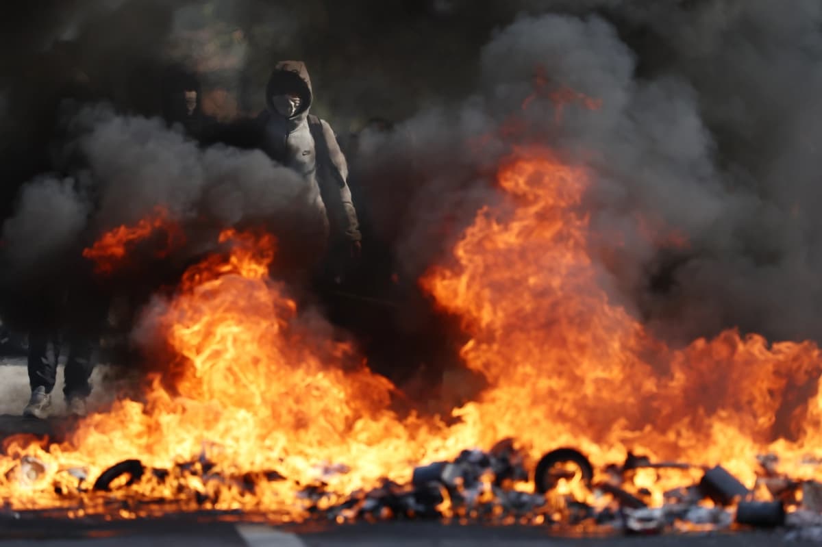Manifestantes provocan incendios durante enfrentamientos con la policía en una marcha por las calles de Aubervilliers, un suburbio al norte de París, Francia, el 1 de octubre de 2026. (Tom Nicholson/Getty Images).