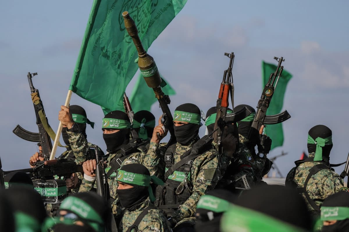Combatientes del grupo terrorista palestino Hamás aseguran una zona antes de entregar a un rehén israelí-estadounidense a un equipo de la Cruz Roja en la ciudad de Gaza el 1 de febrero de 2025, en el marco del cuarto intercambio de rehenes. (Saeed Jaras/Middle East Images/AFP vía Getty Images).