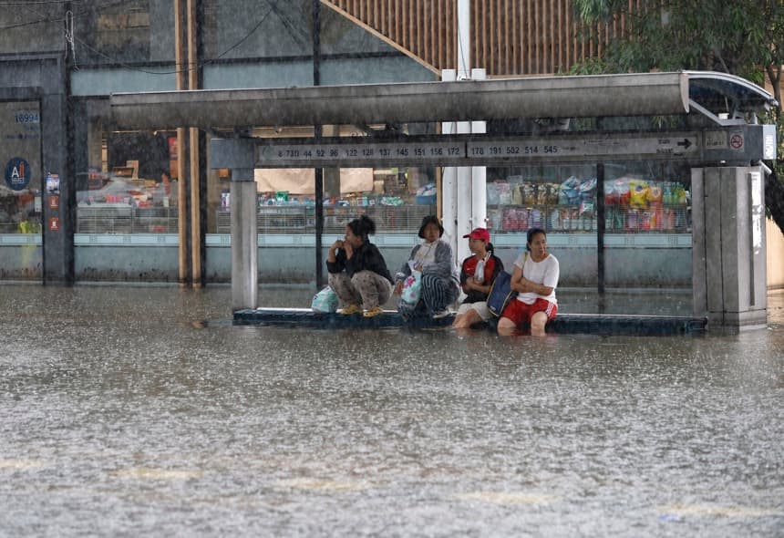 Residentes tailandeses esperan un camión para trasladarse durante un fuerte aguacero en el distrito inundado de Bangkapi, en la capitalina Bangkok, declarada zona de desastre por inundaciones tras persistentes y fuertes lluvias. (EFE/EPA/RUNGROJ YONGRIT)
