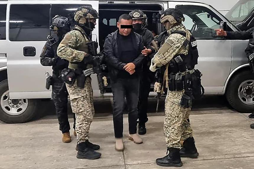 Fotografía tomada de la cuenta oficial en X @OHarfuch del secretario de Seguridad y Protección Ciudadana, Omar García Harfuch, que muestra a integrantes del Ejército custodiando a Iván Cazarín Molina (c), alias 'El Tanque'. (EFE/ @OHarfuch)