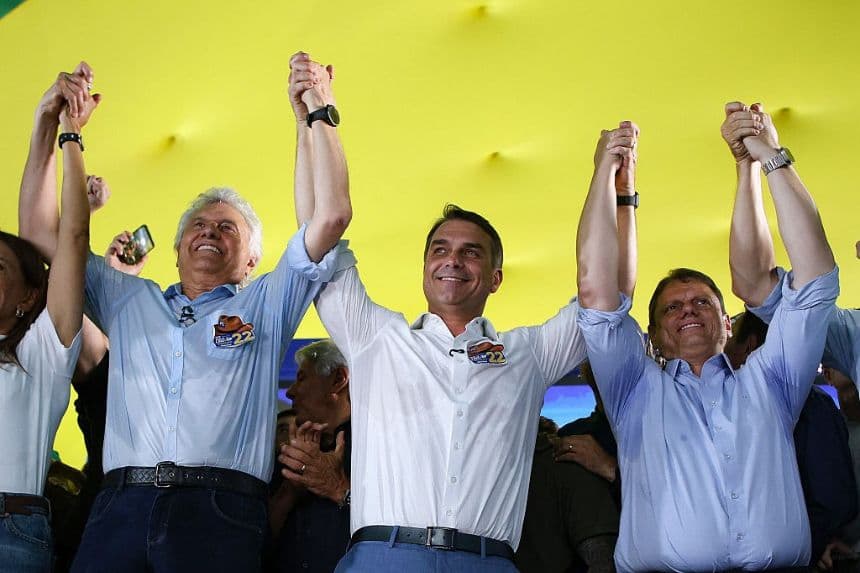 El senador de derecha y candidato presidencial del Partido Liberal (PL) de Brasil, Flavio Bolsonaro (C), saluda con la mano junto al ex candidato presidencial Ronaldo Caiado (I) y al gobernador de São Paulo, Tarcisio de Freitas, durante un mitin en Goiânia, en el estado de Goiás (Brasil), el 6 de octubre de 2026. (Sergio Lima / AFP vía Getty Images)