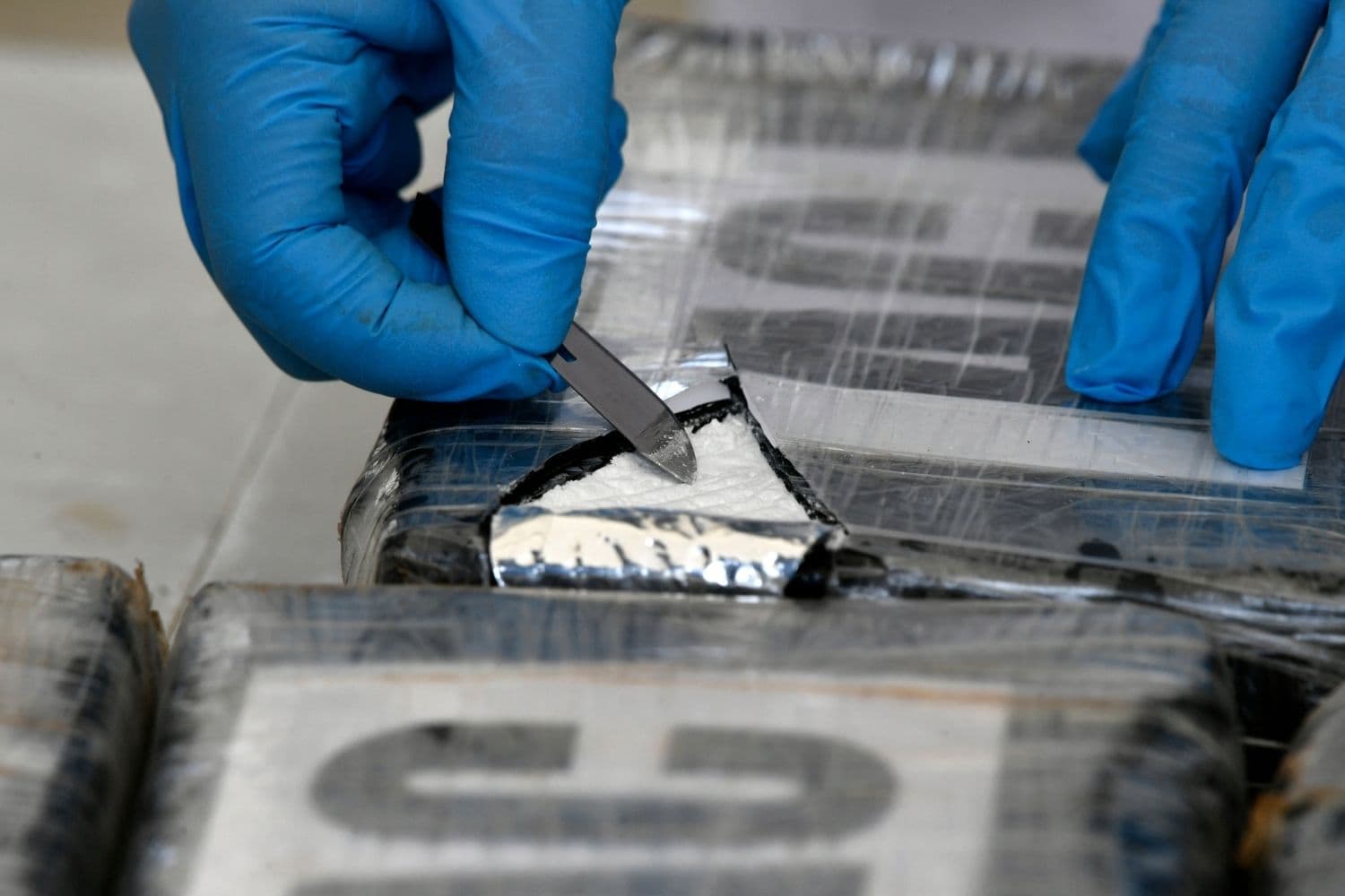 Imagen ilustrativa: Persona realiza una prueba de campo en un paquete que contiene clorhidrato de cocaína. ( Orlando SIERRA / AFP via Getty Images)