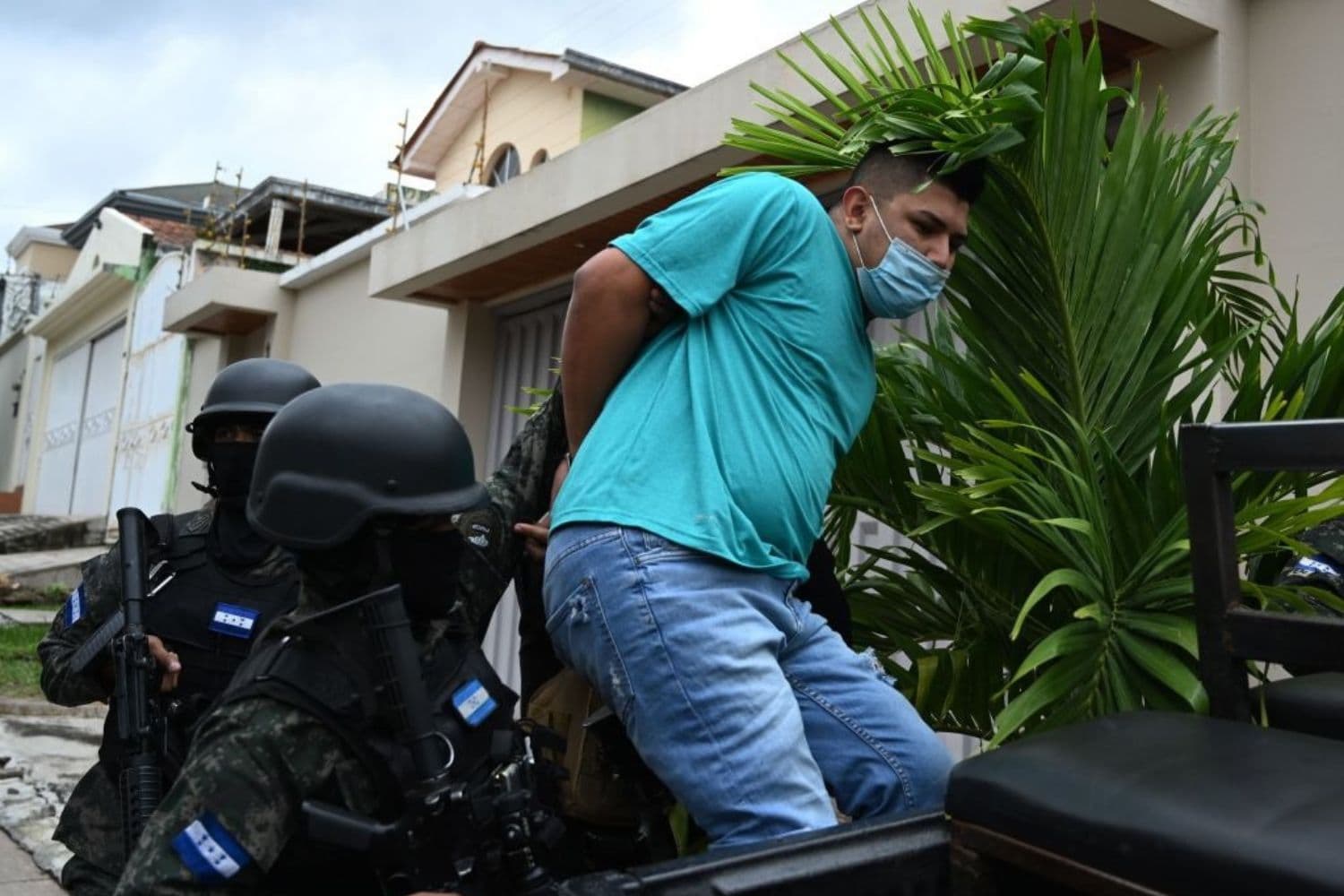 Miembros de la Fuerza Nacional contra las Maras y las Pandillas (FNAMP) detienen a José Alejandro Núñez Cruz (Dcha.), presunto administrador de la banda criminal Mara Salvatrucha 13 (MS-13), en una zona residencial exclusiva de Tegucigalpa, el 26 de noviembre de 2020. La captura del presunto miembro de la banda tuvo lugar en el marco de la operación "Chacal", dirigida contra estructuras criminales vinculadas al tráfico de personas hacia Estados Unidos y que opera en el Triángulo del Norte, formado por El Salvador, Guatemala y Honduras. (ORLANDO SIERRA/AFP vía Getty Images)