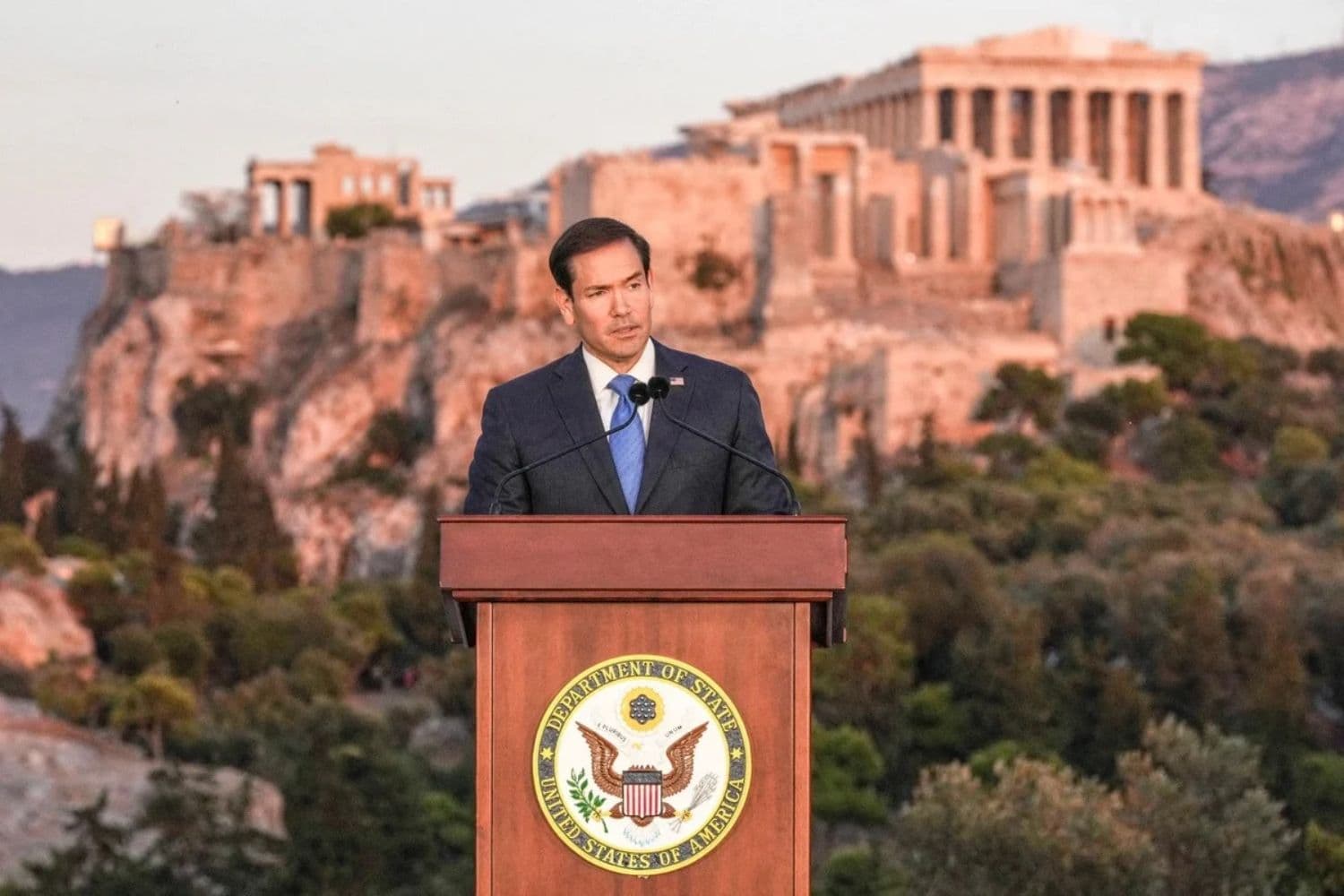 El secretario de Estado Marco Rubio pronuncia un discurso en la colina del Pnyx, donde los antiguos atenienses celebraban sus asambleas democráticas, con el antiguo templo del Partenón en lo alto de la Acrópolis como telón de fondo, en Atenas, el 7 de octubre de 2026. (Mark Schiefelbein/Pool/AFP vía Getty Images)