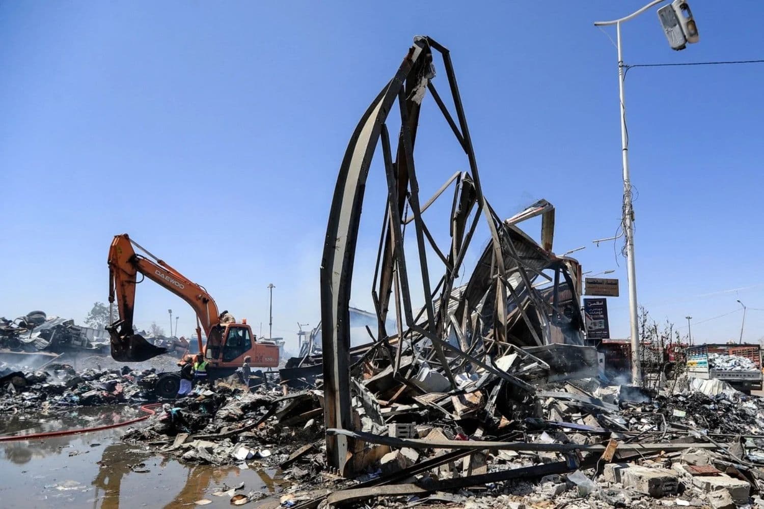Una excavadora retira escombros en el lugar donde, según se informó, se produjo un ataque aéreo saudí durante la noche contra una fábrica de espuma en el barrio de Al-Rawda, en Saná, Yemen, el 9 de octubre de 2026. (Mohammed Huwais/AFP vía Getty Images)