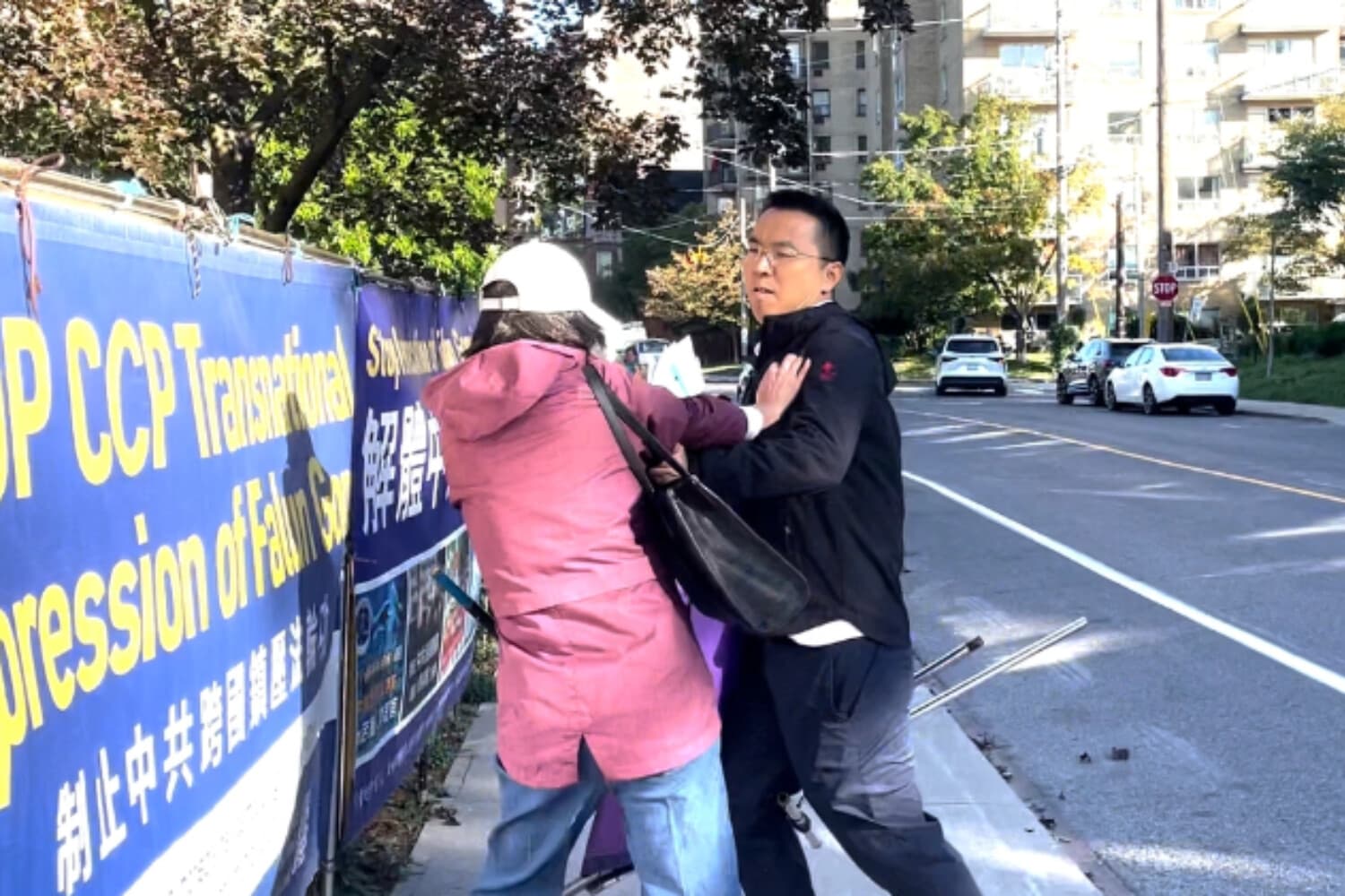 Un hombre ataca a un practicante de Falun Gong en una acera pública frente al Consulado de China en Toronto el 22 de septiembre de 2026. (Captura de pantalla/Imagen cedida).