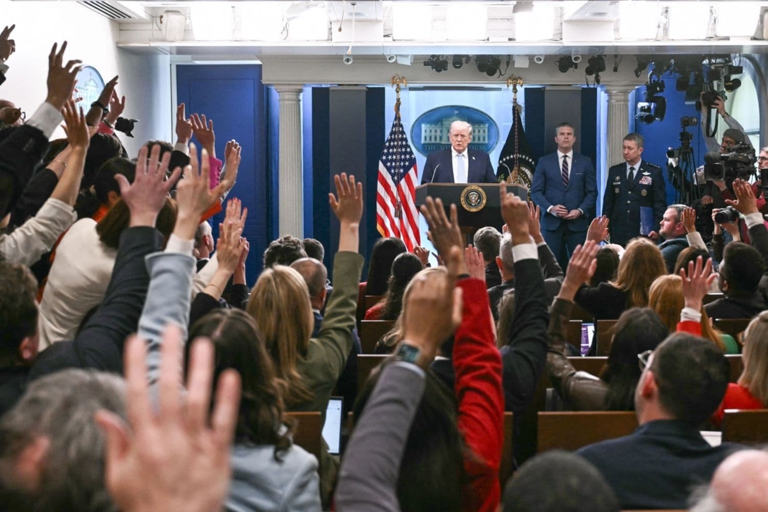 El presidente Donald Trump, junto al secretario de Guerra Pete Hegseth y el jefe del Estado Mayor Conjunto, el general Dan Caine, responde preguntas mientras habla sobre el conflicto en Irán en la Sala de Prensa James S. Brady de la Casa Blanca en Washington, el 6 de abril de 2026. (Brendan Smialowski/AFP vía Getty Images)