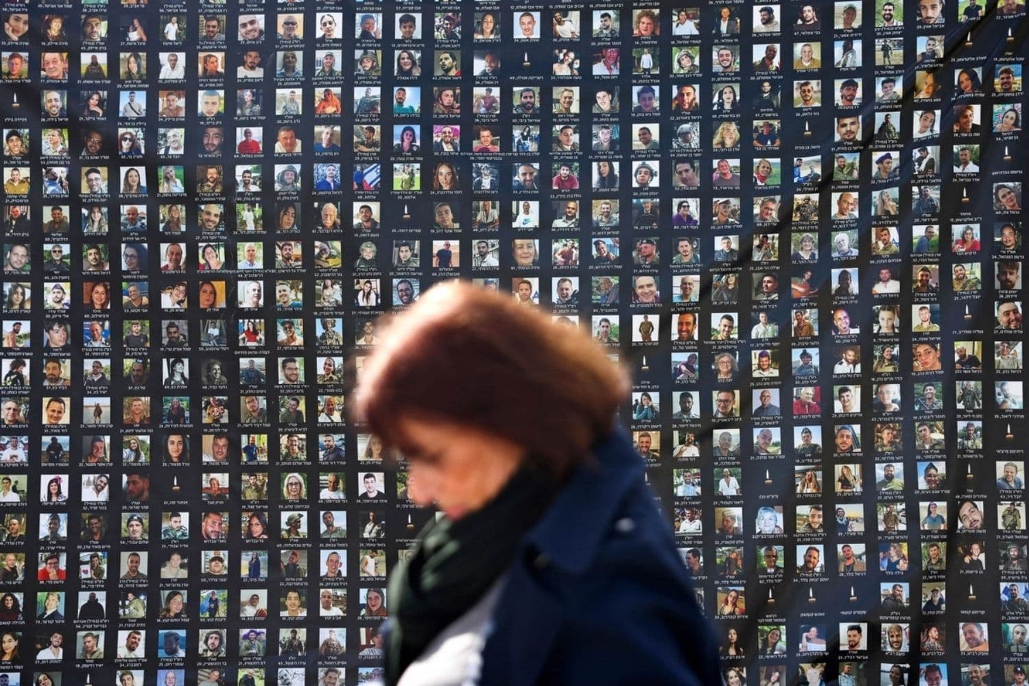 Una mujer pasa junto a carteles de rehenes que anteriormente estaban en poder del grupo militante palestino Hamás en la Franja de Gaza, el día después de que se devolvieran los restos del último rehén, en Jerusalén, el 27 de enero de 2026. (Ahmad Gharabli/AFP vía Getty Images)