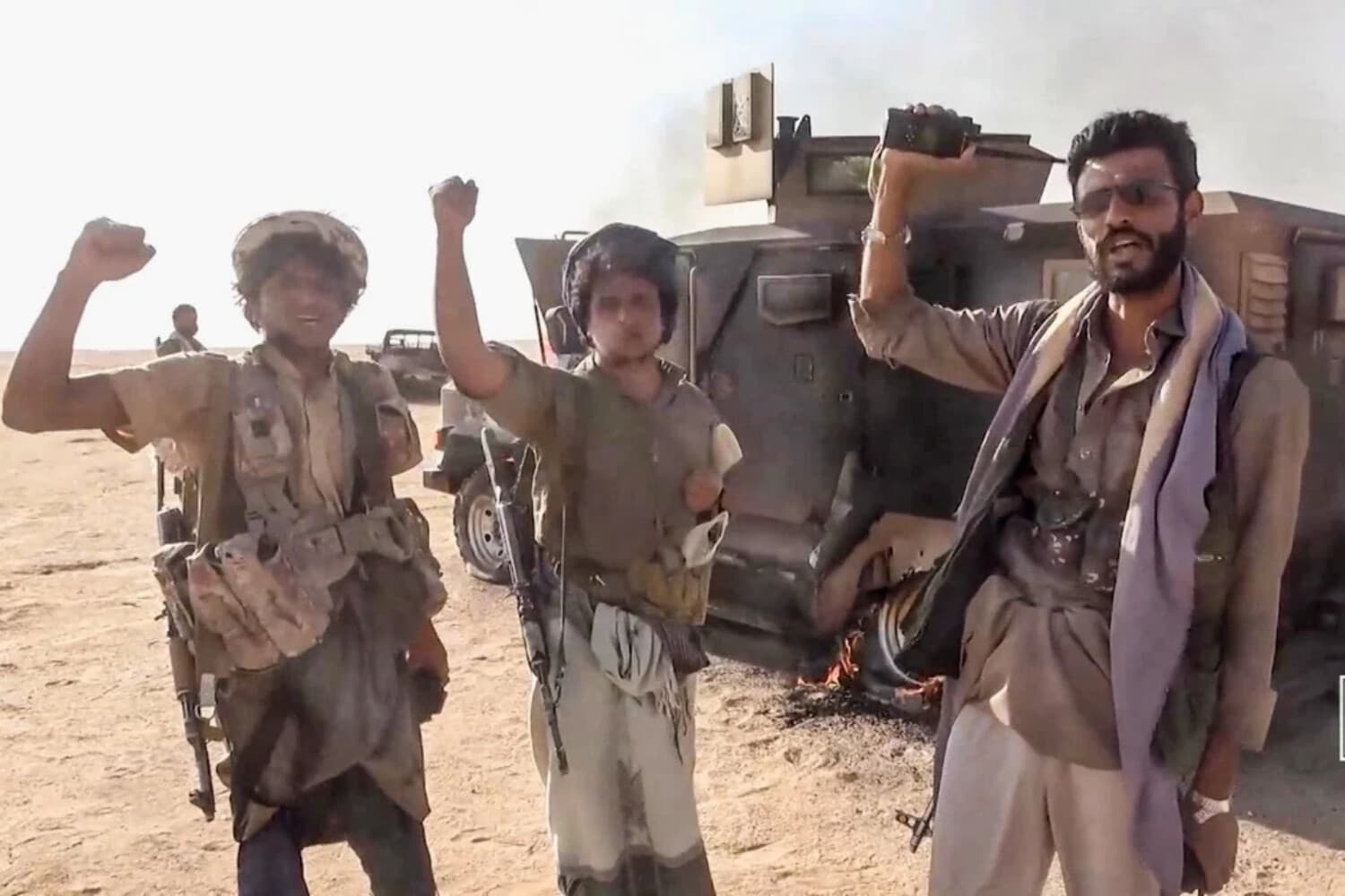 Combatientes hutíes alineados con Irán posan junto a un vehículo destruido tras lo que la fuente describió como un ataque contra fuerzas respaldadas por Arabia Saudí en el lugar indicado como la gobernación de al Jawf, Yemen, en esta captura de pantalla tomada de un vídeo publicado por los medios militares hutíes el 15 de septiembre de 2026. (Medios Militares Hutíes/Reuters).