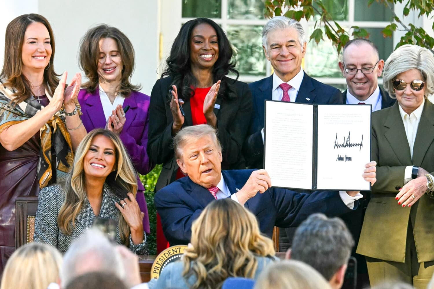 El presidente Donald Trump sostiene una orden ejecutiva firmada junto a la primera dama, Melania Trump, durante una ceremonia de firma celebrada en el Jardín de las Rosas de la Casa Blanca, en Washington, el 19 de octubre de 2026. La orden ejecutiva tiene por objeto crear una División de Salud de la Mujer en los Institutos Nacionales de Salud y un Grupo de Trabajo de la Casa Blanca sobre la Salud de la Mujer. (Jim Watson / AFP vía Getty Images).