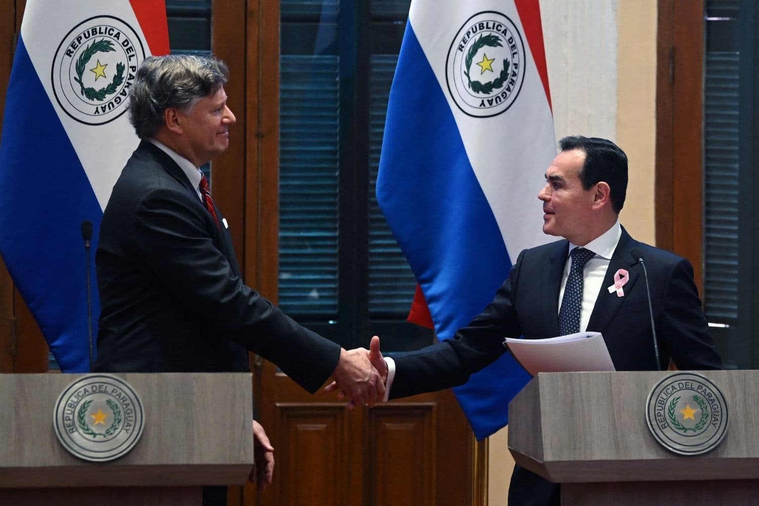 El subsecretario de Estado de EE. UU., Christopher Landau (izq.), estrecha la mano del ministro de Relaciones Exteriores de Paraguay, Rubén Ramírez Lezcano, durante una conferencia de prensa conjunta en Asunción el 19 de octubre de 2026. (DANIEL DUARTE / AFP vía Getty Images)