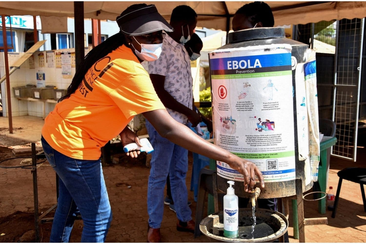 Las personas utilizan una estación de desinfección para quienes ingresan a los servicios de inmigración de Kenia en el puesto fronterizo "Busia One Stop", un punto de cruce entre Kenia y Uganda, el 8 de octubre de 2026. (James Keyi/Reuters)