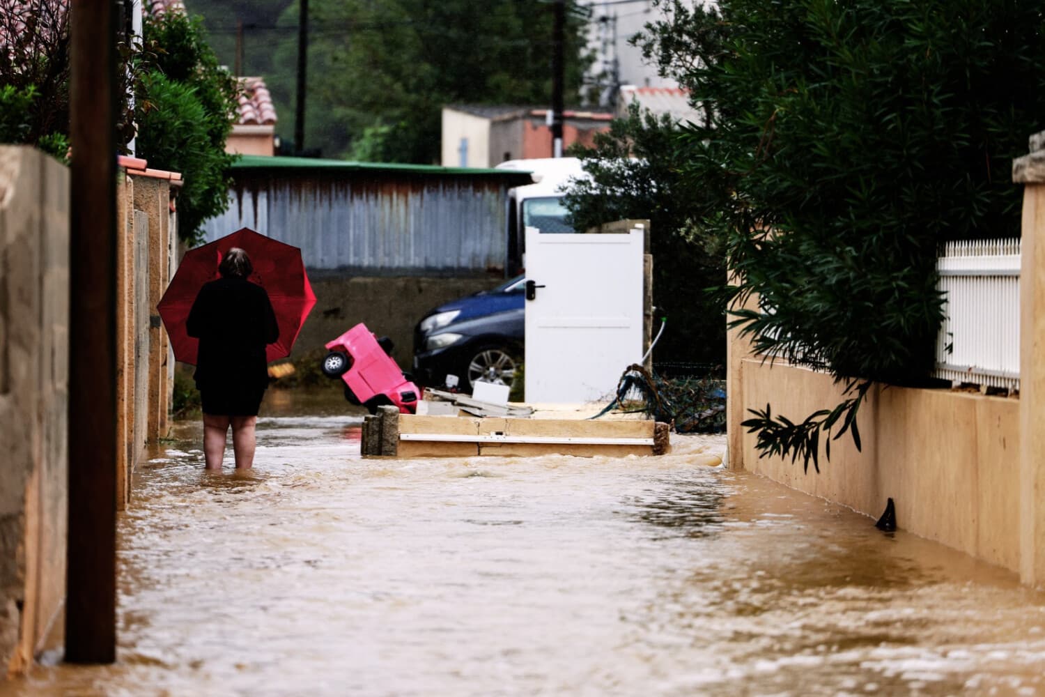 Un vecino camina con un paraguas por una calle inundada en una zona residencial tras las fuertes lluvias caídas en Saint-Mitre-les-Remparts, cerca de Marsella, en el sureste de Francia, el 20 de octubre de 2026. (Thibaud MORITZ / AFP vía Getty Images)