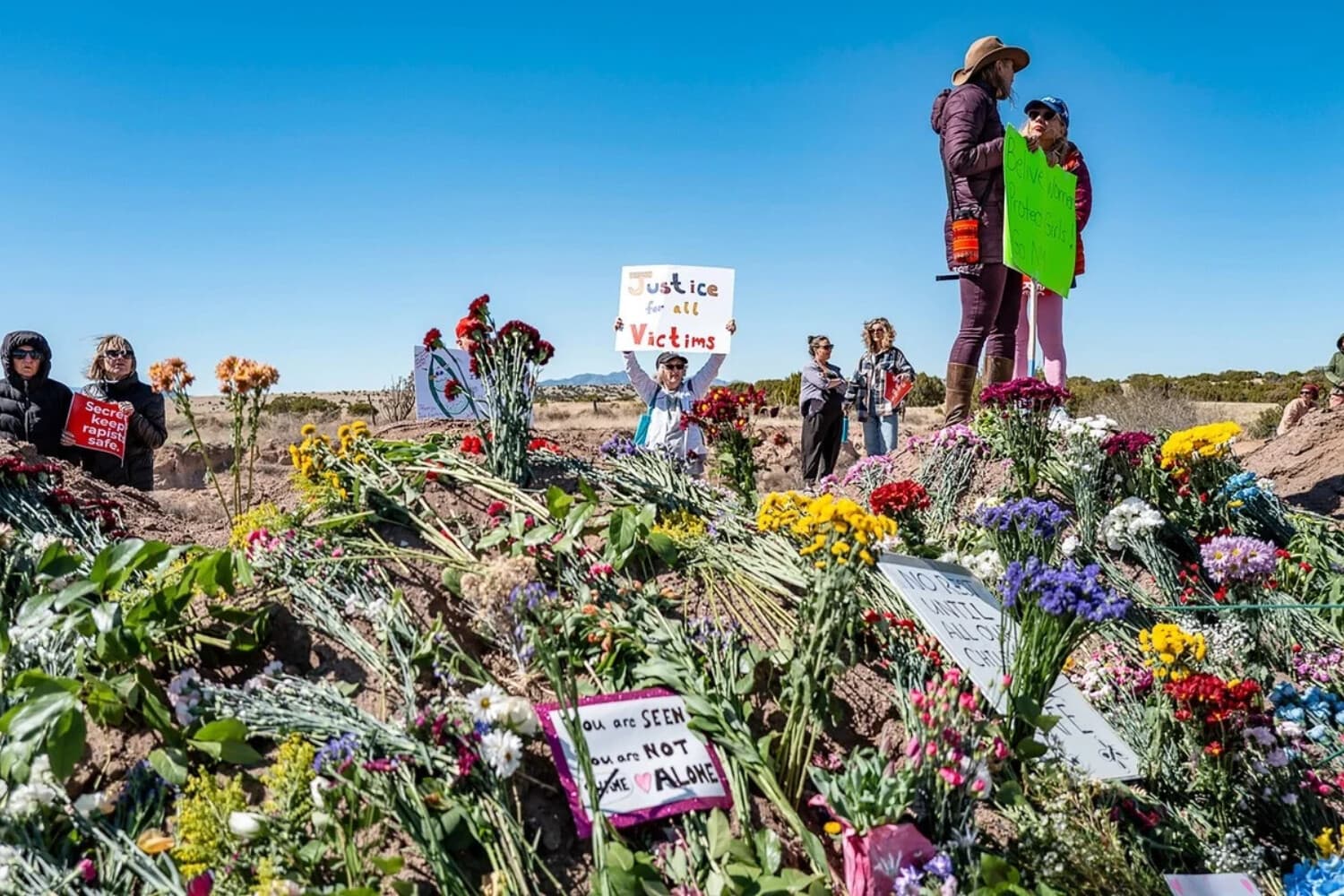 Los manifestantes se reúnen cerca de la entrada del Zorro Ranch de Jeffrey Epstein para ayudar a reconstruir el Monumento a los Supervivientes a las afueras de Santa Fe, Nuevo México, el 8 de marzo de 2026. (Roberto E. Rosales/Getty Images).