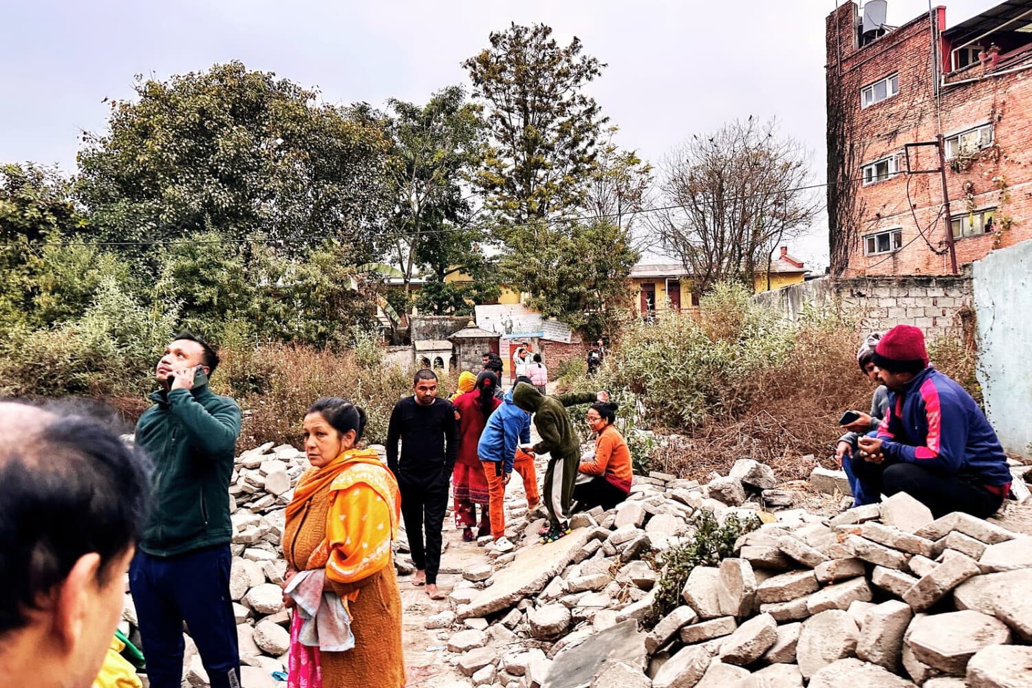La gente se reúne en un espacio abierto tras las sacudidas sísmicas registradas en Katmandú, en la madrugada del 7 de enero de 2025. (SUNIL SHARMA/AFP vía Getty Images)