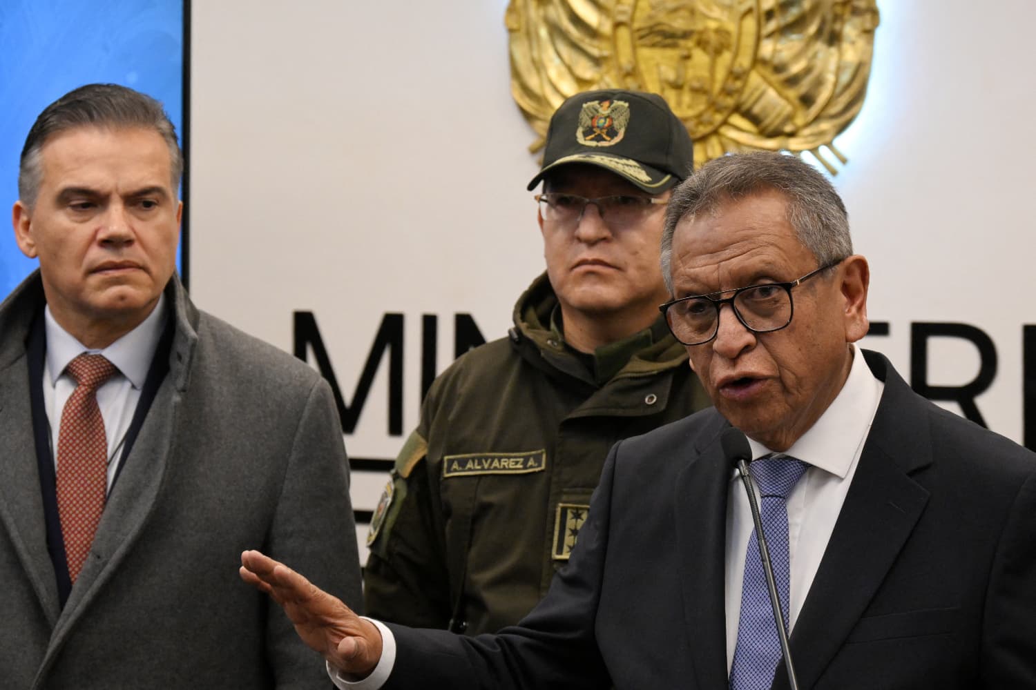 El ministro de gobierno de Bolivia, Marco Antonio Oviedo (Der.), habla junto al ministro de Defensa, Ernesto Justiniano (Izq.), y al comandante general de la Policía Boliviana, Adrián Álvarez, en una conferencia de prensa que anunció el desmantelamiento de una organización criminal que, presuntamente, operaba desde el interior de una institución estatal de alto nivel, en La Paz, el 1 de octubre de 2026. Oviedo informó que el fiscal general de Bolivia, Roger Mariaca, fue detenido el 30 de septiembre de 2026 en Santa Cruz, bajo sospecha de lavado de dinero y narcotráfico. (Aizar RALDES / AFP vía Getty Images)